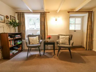 a living room with two chairs and a table at Lower Tamsquite in Bodmin