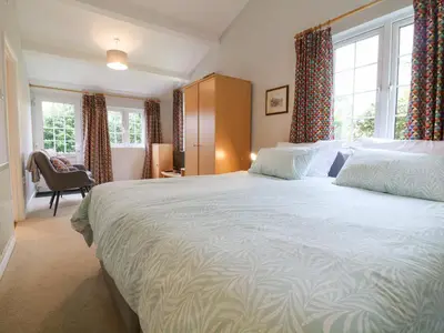 a bedroom with a large bed and windows at Lower Tamsquite in Bodmin