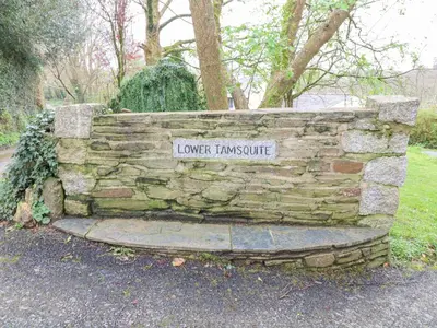 a stone wall with a sign that reads lowerkinsotide at Lower Tamsquite in Bodmin