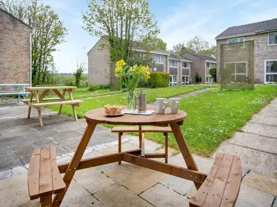 a wooden table and two chairs on a patio at Manor Haven - Atlantic Reach in Saint Columb Major