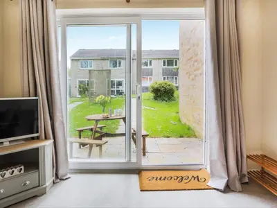 an open door to a patio with a view of a yard at Manor Haven - Atlantic Reach in Saint Columb Major