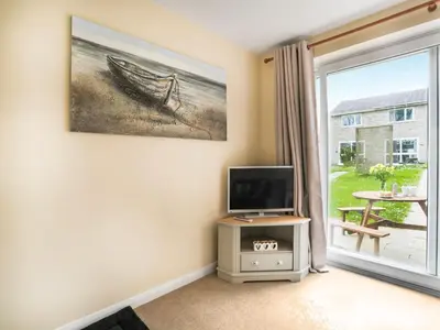 a living room with a tv and a window at Manor Haven - Atlantic Reach in Saint Columb Major