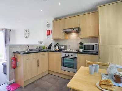 a kitchen with wooden cabinets and a wooden table at Manor Haven - Atlantic Reach in Saint Columb Major