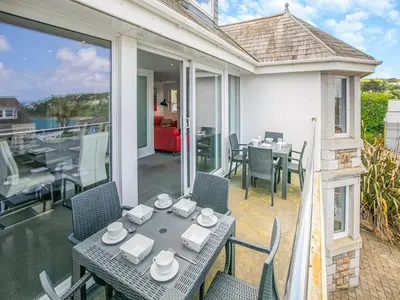 a patio with a table and chairs on a balcony at Chapel View in Carbis Bay