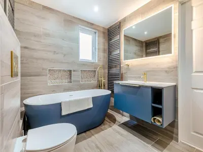 a bathroom with a blue tub and a toilet at Chapel View in Carbis Bay