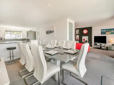 a dining room with a table and white chairs at Chapel View in Carbis Bay