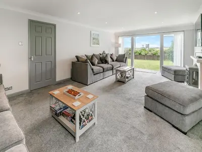 a living room with a couch and a table at The Lodge in Helston