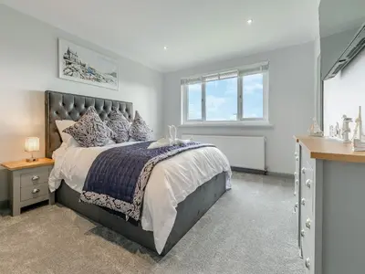 a bedroom with a large bed and a window at The Lodge in Helston