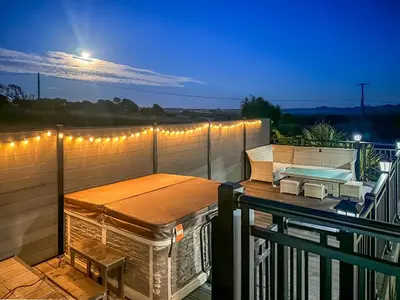 a balcony with a table and lights on it at The Lodge in Helston