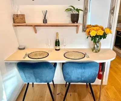 a table with two chairs and a bottle of wine at Rumford Heights guest apartment in Saint Ervan