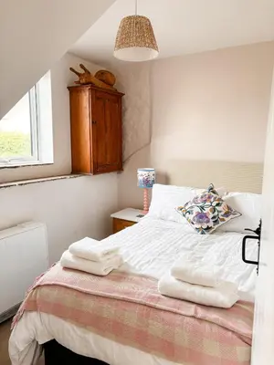 a bedroom with a bed with towels on it at April Cottage in Tintagel