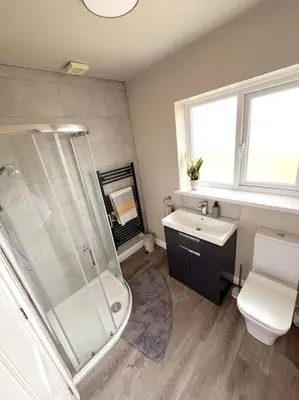a bathroom with a shower and a toilet and a sink at Rymer-Leigh in Marazion