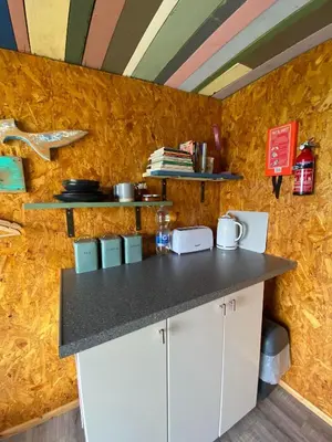 a kitchen with a counter and a yellow wall at Sunrise Cabin in Carbis Bay