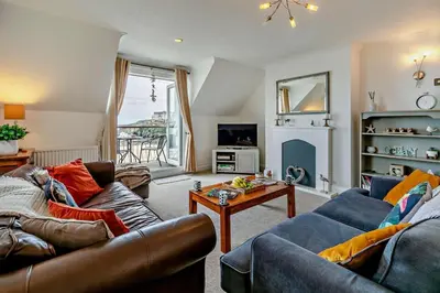 a living room with two couches and a table at 3 Bed in Looe oc-w29227 in Looe