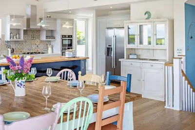 a kitchen and dining room with a wooden table and chairs at 6 Bed in Newquay oc-e18072 in Newquay