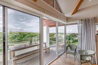 a room with a table and chairs and a large window at 6 Bed in Newquay oc-e18072 in Newquay