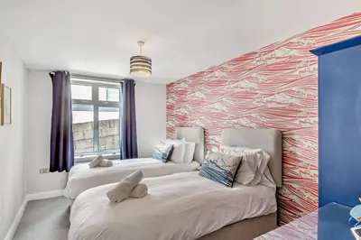 two beds in a room with a colorful wall at 6 Bed in Newquay oc-e18072 in Newquay
