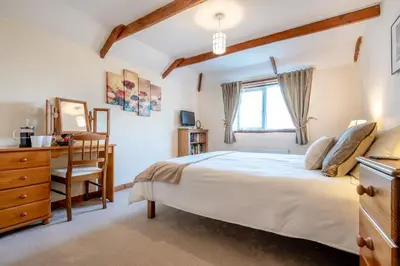 a bedroom with a bed and a desk and a chair at 3 Bed in St. Merryn oc-m29320 in St Merryn