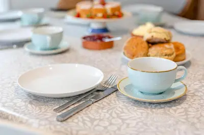 a table with plates and a cup of coffee and pastries at 3 Bed in Golant oc-o29307 in Golant