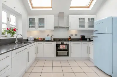 a white kitchen with white cabinets and appliances at 3 Bed in Golant oc-o29307 in Golant