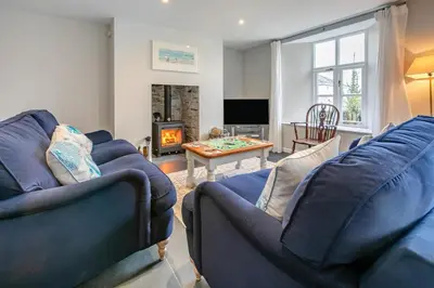 a living room with two blue couches and a fireplace at 3 Bed in Golant oc-o29307 in Golant