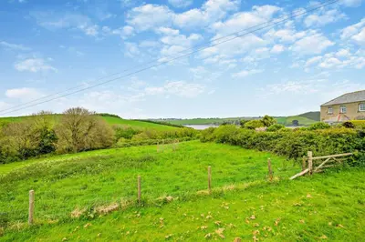 a green field with a fence and a house at 2 Bed in St. Issey oc-t29235 in Saint Issey