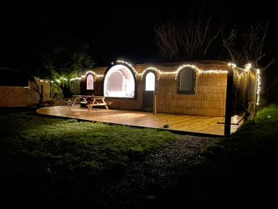 a yurt lit up at night with lights at Dreckly cabin - Lydcott Glamping with Cornish sea views in Looe