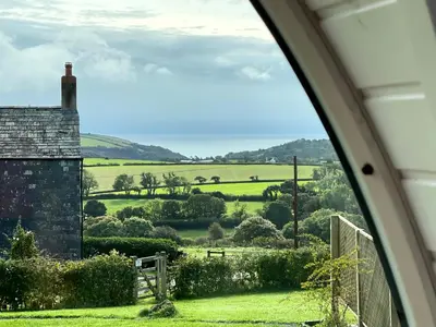 a view of the countryside from a house window at Dreckly cabin - Lydcott Glamping with Cornish sea views in Looe