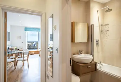 a bathroom with a sink and a tub and a table at 4 Fernhill in Carbis Bay