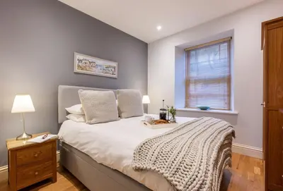 a bedroom with a bed and a window at 4 Fernhill in Carbis Bay