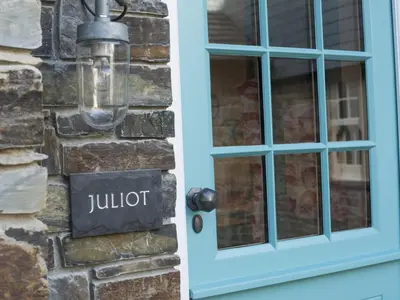 a blue door with a judot sign on a brick wall at Apartment Juliot by Interhome in St Ives