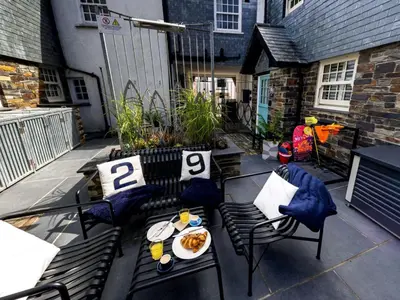 a patio with two chairs and a table with food on it at Holiday Home Wella by Interhome in St Ives