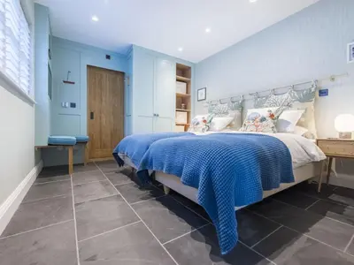 a bedroom with a large bed with blue walls at Holiday Home Wella by Interhome in St Ives