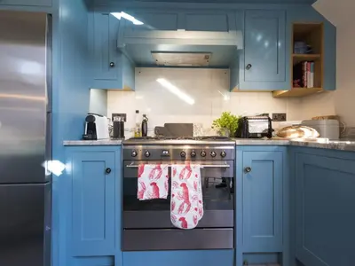 a kitchen with blue cabinets and a stove with towels at Holiday Home Wella by Interhome in St Ives