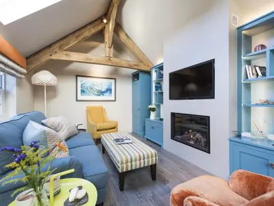 a living room with a blue couch and a fireplace at Holiday Home Wella by Interhome in St Ives