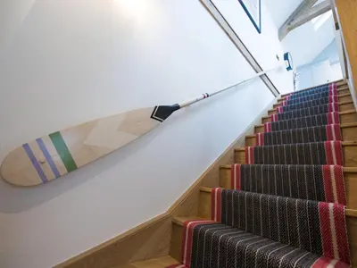 a surfboard hanging on a wall next to stairs at Holiday Home Iris by Interhome in St Ives
