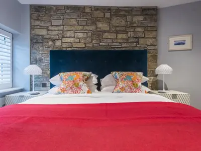 a bedroom with a large bed with a brick wall at Holiday Home Iris by Interhome in St Ives