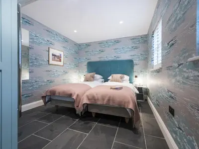 a bedroom with a large bed with blue walls at Holiday Home Iris by Interhome in St Ives