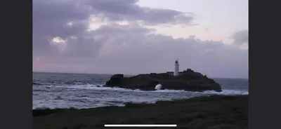 a lighthouse on a small island in the ocean at Claire’s place in Hayle