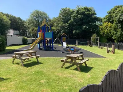 a park with two picnic tables and a playground at Claire’s place in Hayle