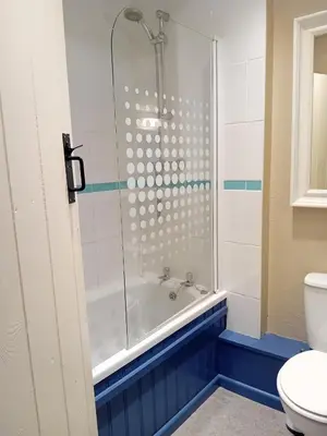 a bathroom with a shower and a tub and a toilet at Farm Cottage, Chypons Farm, Rural St Ives in Penzance