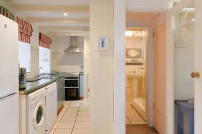 a kitchen with a washer and dryer in it at Farm Cottage, Chypons Farm, Rural St Ives in Penzance