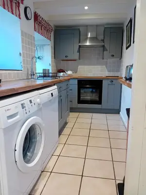 a kitchen with a washer and dryer at Farm Cottage, Chypons Farm, Rural St Ives in Penzance