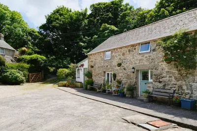 an old stone house with a bench at River Cottage, Chypons Farm, Rural St Ives in Nancledra