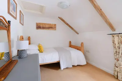 a white bedroom with a bed and a mirror at River Cottage, Chypons Farm, Rural St Ives in Nancledra