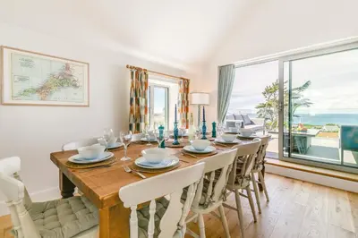a dining room with a table and chairs and a large window at 4 Bed in Trevone oc-p28959 in St Merryn