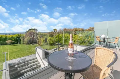 a table with a bottle of wine on a balcony at 4 Bed in Trevone oc-p28959 in St Merryn