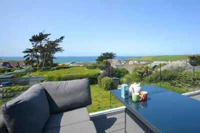 a blue couch on a balcony with a view of the ocean at 4 Bed in Trevone oc-p28959 in St Merryn