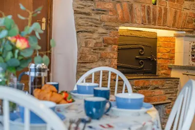 a table with blue cups and chairs and a brick oven at 3 Bed in Padstow oc-h28928 in Padstow
