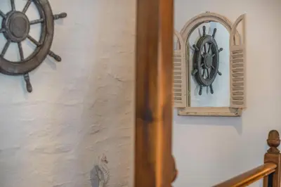 a clock on a wall next to a wooden wheel at 3 Bed in Padstow oc-h28928 in Padstow